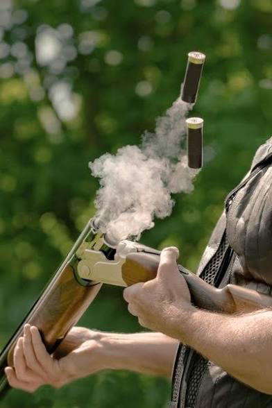 Clay shooting in action with smoke and shells